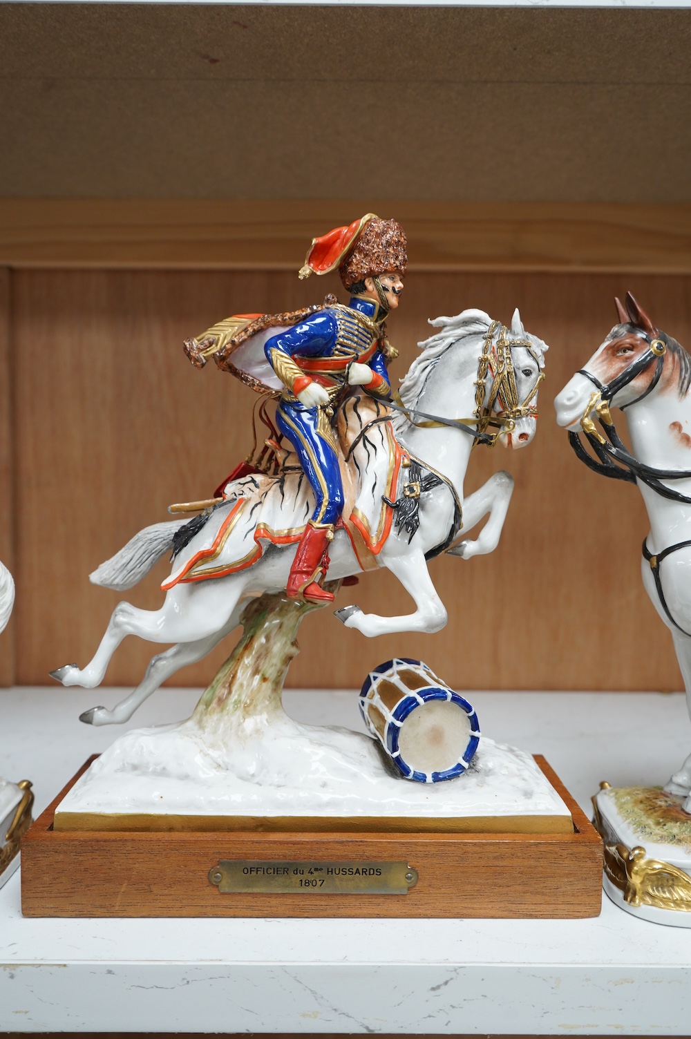 A group of three continental porcelain models of riders on horseback, tallest 27cm